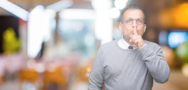 中年街头布西纳阿拉伯男子戴眼镜在孤立的背景要求安静的手指在嘴唇上 沉默和秘密概念 — 图库照片
