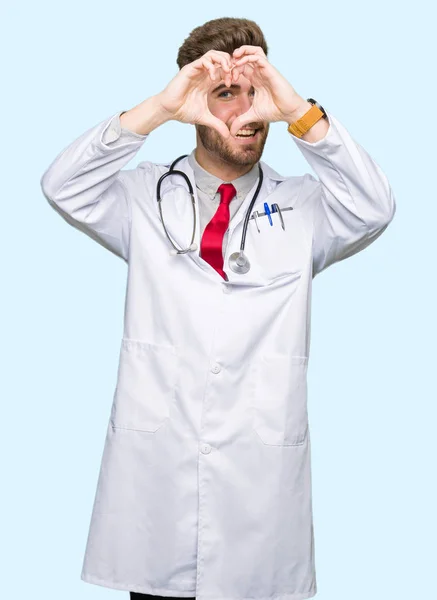 Νεαρός Γιατρός Όμορφος Άνθρωπος Φορώντας Ιατρική Παλτό Κάνει Καρδιά Σχήμα — Φωτογραφία Αρχείου