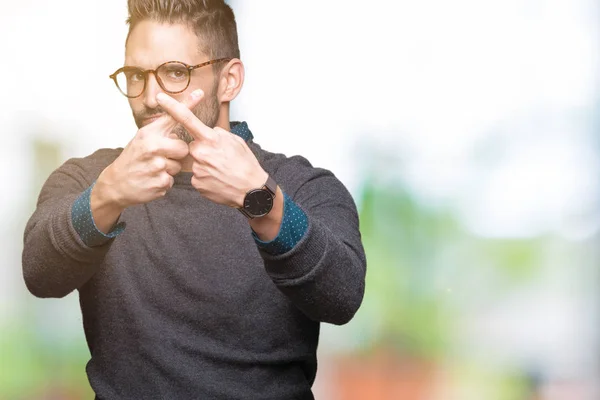 Young handsome man wearing glasses over isolated background Rejection expression crossing fingers doing negative sign