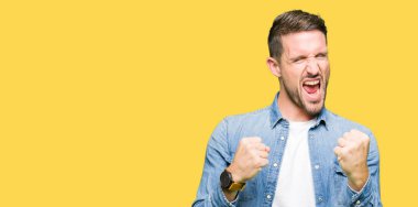 Kot giyen sakal ve mavi gözlü yakışıklı adamla ceket çok mutlu ve heyecanlı kaldırdı kollarını açarak kazanan jest yapıyor, gülümseyen ve başarı için çığlık. Kutlama kavramı.