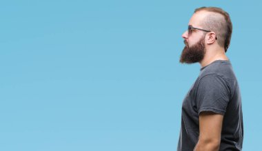 Genç beyaz hipster adam giyen güneş gözlüğü izole arka tarafına, seyir üzerinde dinlenmek doğal yüz emin gülümseme ile pozuyla profili.