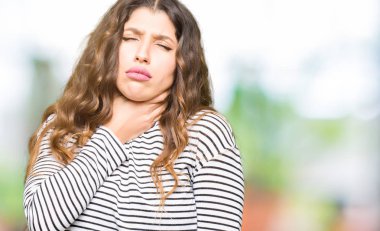 Çizgiler dokunmadan kazak giyen genç güzel kadın ağrılı boyun, boğaz gribi, kesek ve enfeksiyon için