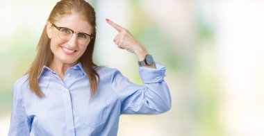 Güzel orta yaş olgun iş kadın gözlük izole üzerinde bir parmak, harika bir fikir ya da düşünce, iyi hafıza ile baş gösteren gülen arka plan