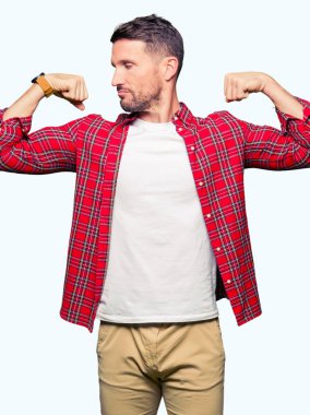 Yakışıklı adam rahat gömlek gösteren giyen gururlu gülümseyen kas silah. Fitness kavramı.