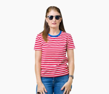 Orta yaş Olgun kadın yüzünde ciddi bir ifade ile izole arka plan üzerinde güneş gözlüğü takıyor. Basit ve doğal kameraya bakıyor.