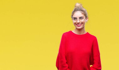 Kırmızı kazak ve gözlük üzerinde giyen genç güzel sarışın kadın arka plan uzak tarafına gülümseme ile yüzünde, doğal ifade arıyorum izole. Kendine güvenen gülüyor.