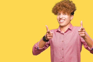 Fotoğraf makinesi ile mutlu ve komik yüz için parmakları işaret afro saçlı genç yakışıklı iş adamı. İyi enerji ve vibes.