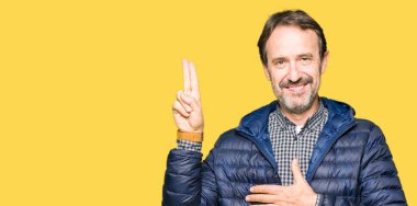 Orta yaş yakışıklı adam giyen kış ceket Swearing göğüs ve bir sadakat sözü yemin yapma parmaklar, el ile