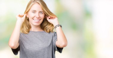 Yüksek sesle müzik gürültü rahatsız ifade parmaklarıyla kulaklarıyla kapsayan izole arka plan üzerinde büyük boy rahat t-shirt giyen güzel ve genç birbayan. Sağır kavramı.