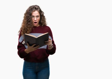 Genç esmer kız izole arka şok sürpriz yüzü, korkuyor ve korku ifadesi ile heyecanlı olan korkmuş üzerinde gözlük takan bir kitap okuma