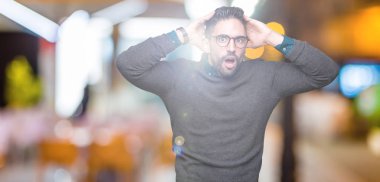 Üzerinde gözlük takan genç yakışıklı adam arka plan deli izole ve baş, korkuyor ve açık ağzı ile şok sürpriz elleriyle korkuttu