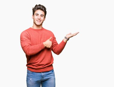 İzole arka plan gösteren palm el ve iş tamam jestle başparmak yukarı, gülümseyen mutlu ve neşeli genç yakışıklı adam