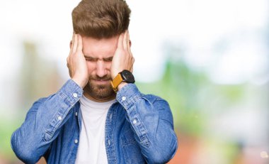 Genç yakışıklı sarışın adam rahat denim ceket çünkü umutsuz ve stresli baş ağrısı acı acı ve Migren. Ellerini kafasına.