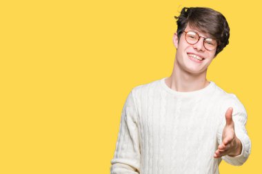 Tebrik ve davet edici dostu sunan karşılıklı gülümseyen izole arka plan üzerinde gözlük takan yakışıklı delikanlı. Başarılı iş.