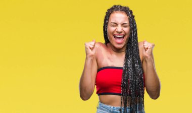 Genç örgülü saç Afrika kökenli Amerikalı ile pigmentasyon leke Doğum işareti izole arka kolları olan başarı için heyecan üzerinde zafer kutluyor gülümseyen kaldırdı. Kazanan kavramı.