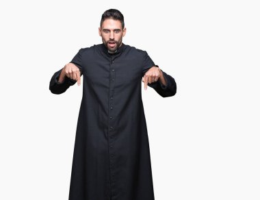 Genç Hıristiyan rahip izole üzerinde arka plan işaretleme aşağı reklam, sürpriz yüz ve açık ağız gösterilen parmakları ile