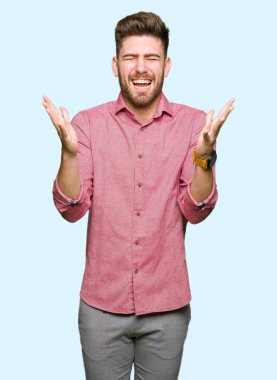 Genç yakışıklı iş casual adam kızgın ve silah ile başarı için deli kutluyor kaldırdı ve heyecanlı çığlık gözler kapalı. Kazanan kavramı