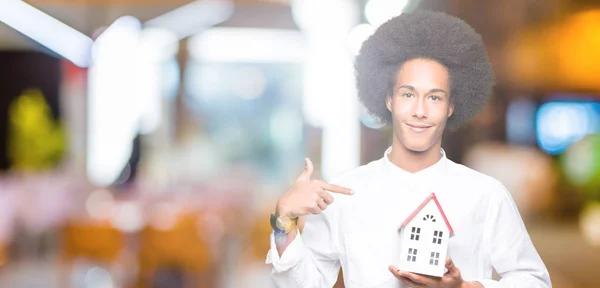 家の驚きを保持してアフロの髪の若いアフリカ系アメリカ人に直面する自分自身に人差し指 — ストック写真