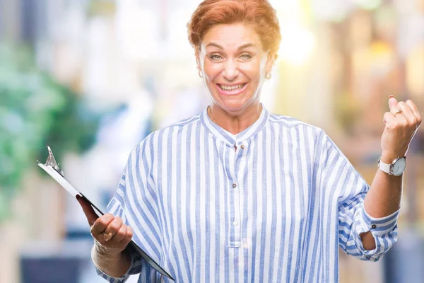 Senior Kaukasische Geschäftsfrau Hält Klemmbrett Über Isoliertem Hintergrund Schreit Stolz — Stockfoto