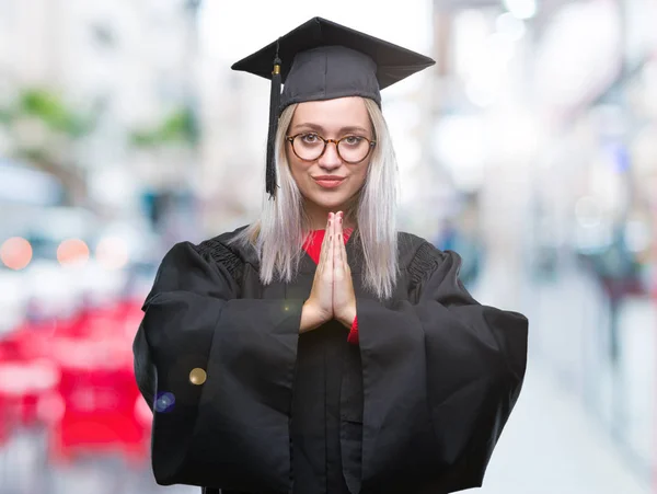 Jonge Blonde Vrouw Afgestudeerde Uniform Dragen Geïsoleerde Achtergrond Bidden Met — Stockfoto