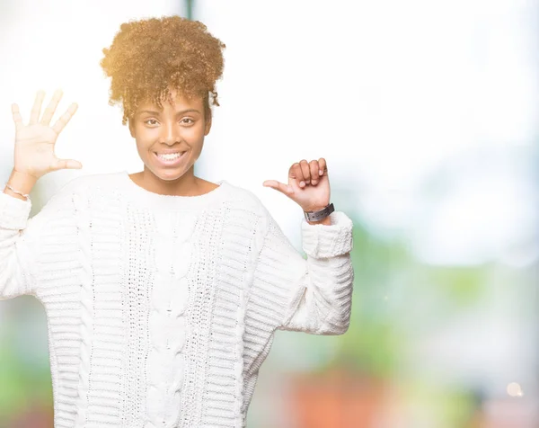 Beautiful young african american woman wearing winter sweater over isolated background showing and pointing up with fingers number six while smiling confident and happy.