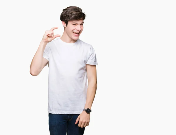 年轻英俊的男人穿着休闲白色 T恤在孤立的背景微笑和自信的手势与手做大小标志与手指 而看和相机 测量概念 — 图库照片