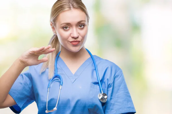 年轻的金发医生医生妇女在孤立的背景示意与手显示大和大尺寸的标志 措施符号 看着镜头微笑 测量概念 — 图库照片