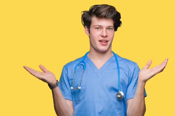 若い医者に医療制服を着て分離両手を見せて笑顔 手のひらを開くは 提示し 広告の比較やバランスの背景 — ストック写真