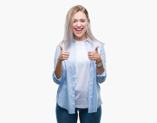 年轻的金发女人在孤立的背景下成功的标志做积极的手势与手 大拇指向上微笑和快乐 看着带着欢快表情的相机 胜利者的手势 — 图库照片