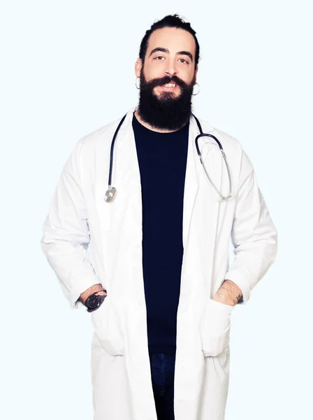 医者の顔に幸せとクールな笑みを浮かべて聴診器と医療のコートを着て長い髪を持つ 幸運な人 — ストック写真