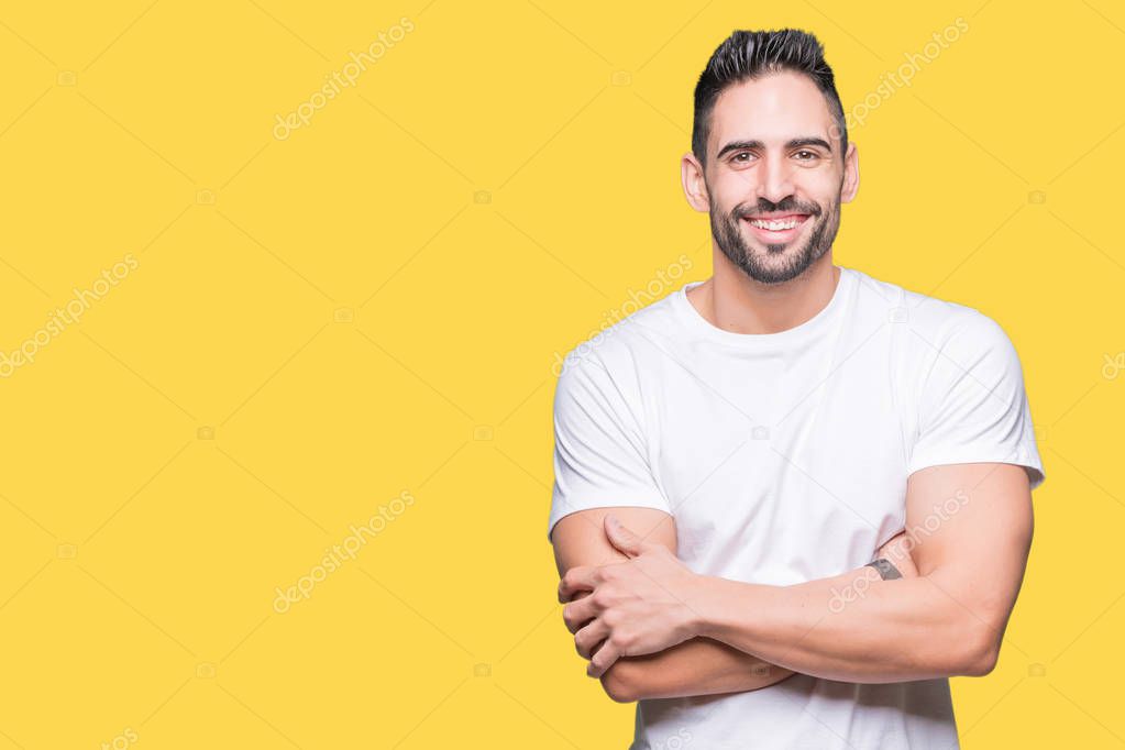 Young man wearing casual white t-shirt over isolated background happy face smiling with crossed arms looking at the camera. Positive person.