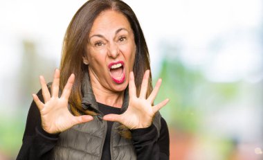 Kış yelek korkuyor ve korku ifade dur hareketi el ile ile dehşete giyen güzel orta yaş kadın şok bağırarak. Panik kavramı.