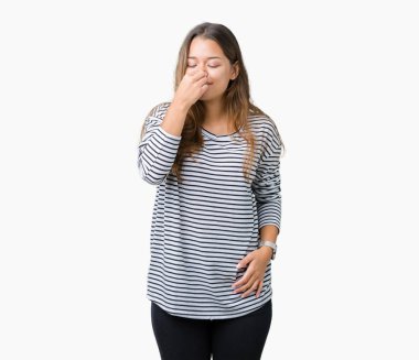 Kazak giyen genç güzel esmer kadın çizgili bir şey pis ve iğrenç kokulu izole arka plan, dayanılmaz koku, holding nefes burun parmaklar ile. Kötü kokuyor kavramı.