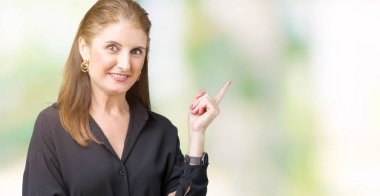 Kameraya bakarak yan el ve parmak ile işaret eden güzel orta yaş olgun iş kadını yüzünde kocaman bir gülümseme ile izole arka plan üzerinde.