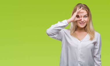 Gülümseyen, parmakları ile mutlu yüz üzerinden seyir göz el ile ok jest yapıyor izole arka plan üzerinde beyaz kadın.