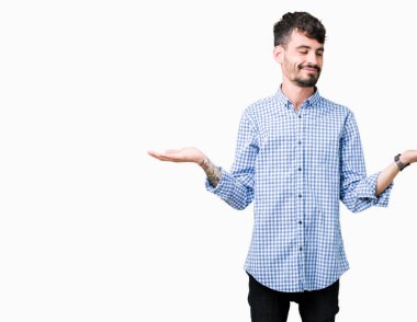 Genç yakışıklı iş adamı izole arka plan gülen gösteren her iki üzerinde açık avuç içi, sunmak ve reklam karşılaştırma ve denge eller