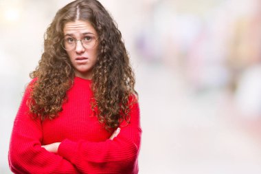 Güzel esmer kıvırcık saçlı Genç kız izole arka plan şüpheci ve sinir, onaylamayan ifade yüz çapraz kolları üzerinde gözlük ve kış kazak giyiyor. Negatif kişi.
