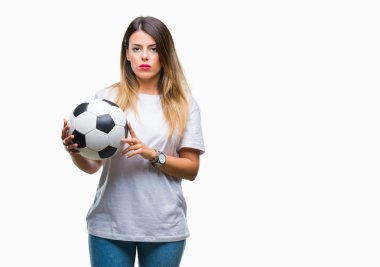 Acımak yüz ciddi düşünüyorum üstünde kendine güvenen bir ifade ile izole arka plan üzerinde futbol topu tutan genç güzel kadın