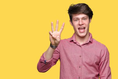 Genç yakışıklı iş adamı gösterilen ve parmakları ile işaret izole arka plan üzerinde üçüncü ise kendinden emin ve mutlu gülümseyerek.