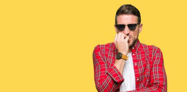 Yakışıklı adam stresli ve gergin ile moda güneş gözlüğü takıyor tırnak ısırma dudaklarından eller. Anksiyete sorunu.