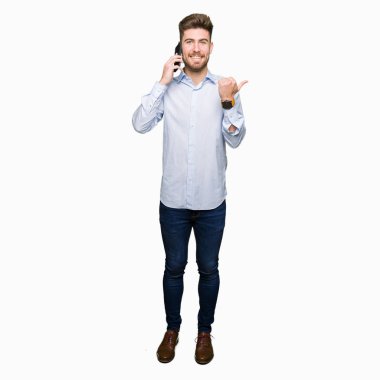 Genç yakışıklı iş işaret ve başparmak kadar mutlu yüz gülümseyen tarafı ile gösterilen Smartphone cep telefonu ile konuşurken adam
