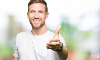 Yakışıklı adam olarak tebrik ve konuksever dost sunan karşılıklı gülümseyen casual beyaz t-shirt giyiyor. Başarılı iş.