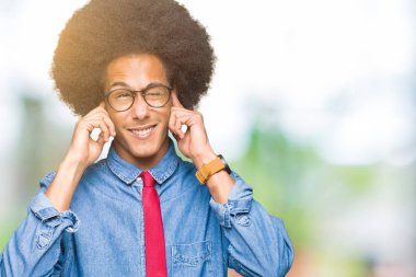 Gözlük ve yüksek sesle müzik gürültü rahatsız ifade parmaklarıyla kulaklarıyla kapsayan kırmızı kravat giyen afro saçlı genç Afro-Amerikalı iş adamı. Sağır kavramı.