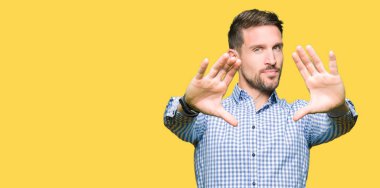 Yakışıklı iş adamı mavi çerçeve kullanarak el avuç içi ve parmaklar, kamera perspektif yapıyor gülen gözler