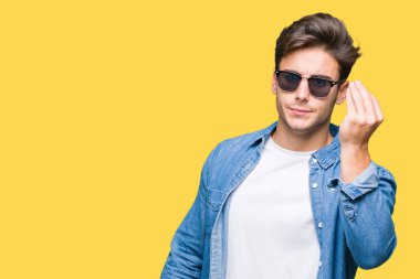 Genç yakışıklı adam giyen güneş gözlüğü izole arka yapıyor İtalyan üzerinde el ve parmak emin ifadeyle jest