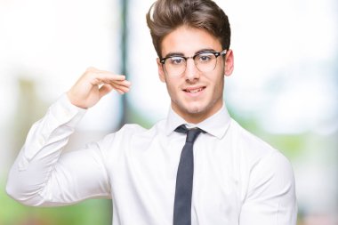 İzole arka plan eller eller büyük gösterilen ve büyük boy işareti, ölçü birimi sembolü ile üzerinde gözlük takan genç iş adamı. Kameraya bakarak gülümsüyordu. Ölçüm kavramı.