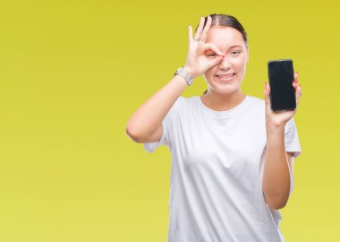 Genç güzel beyaz kadın Smartphone ekran ile mutlu yüz el parmaklarının arasından seyir göz üzerinde ok işaretiyle yapıyor gülümseyen izole arka plan üzerinde gösterilen