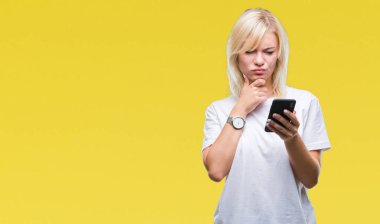 Genç güzel sarışın kadın Smartphone izole arka plan ciddi bir yüz düşünme hakkında soru, çok karışık bir fikir üzerinde kullanma