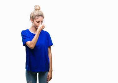 Üzerinde mavi t-shirt giyen genç güzel sarışın ve mavi gözlü kadın arka plan duygu yorgunluk ve baş ağrısı gözleri ve burun sürtme yorgun izole. Stres ve hayal kırıklığı kavramı.