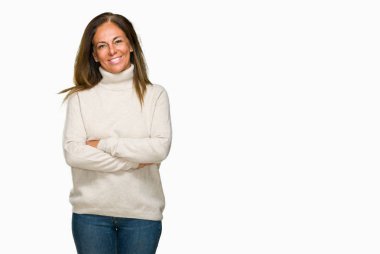 Üzerinde kış kazak giyen güzel orta yaş yetişkin kadın mutlu yüz ile gülümseyerek kameraya seyir silah geçti arka plan izole. Olumlu bir kişi.